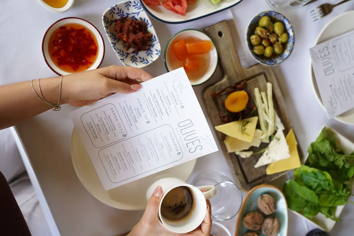 Olives menüsü, peynir tabağı, zeytin ve kahveyle kahvaltı masası